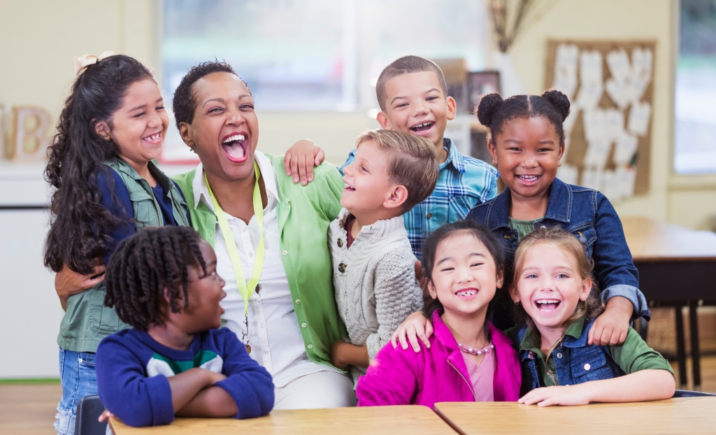 Example of a picture of a diverse classroom with the teacher and students having fun and smiling.